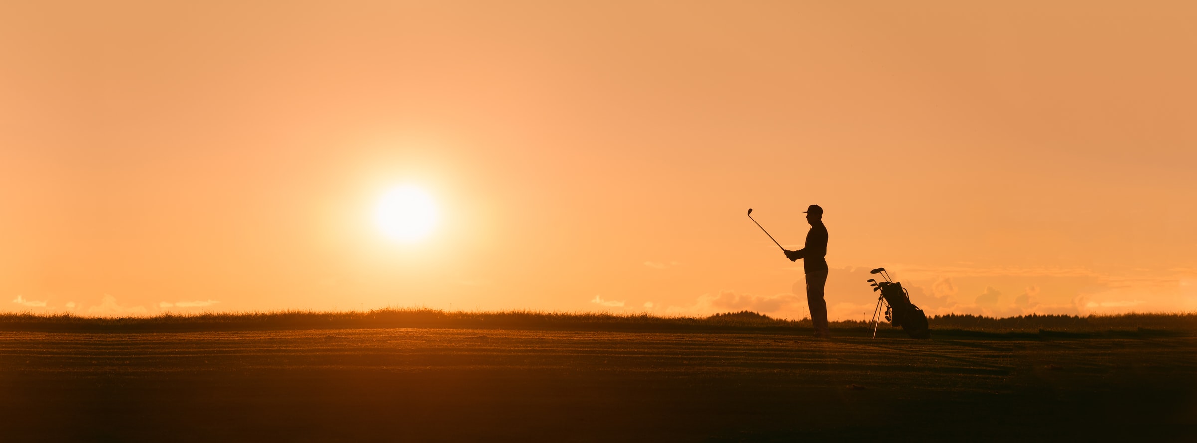 Person lining up shot at sunset